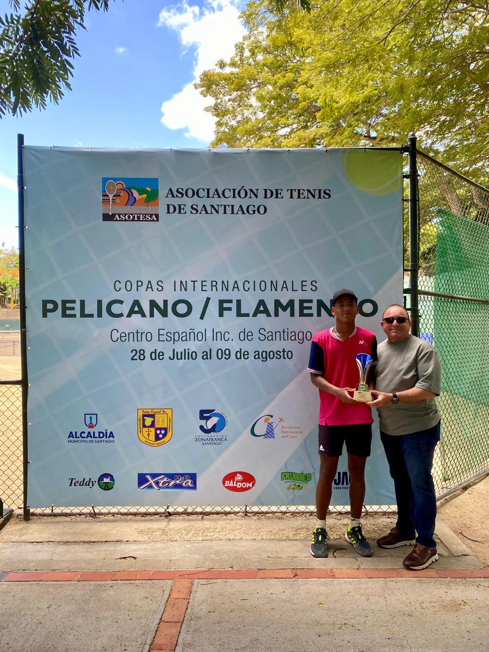Isaac Guerrero, campeón de sencillos de la Copa Pelícano, premiado por Euler Veloz, directivo del Centro Español de Santiago.